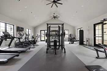 A spacious gym with treadmills, elliptical machines, and a weightlifting area.